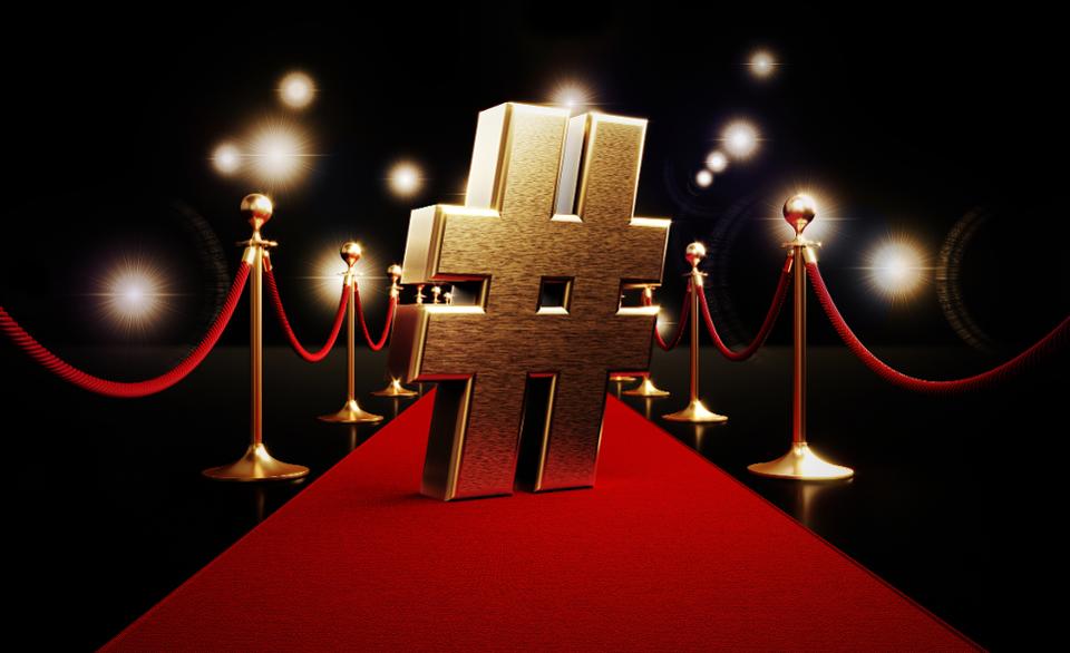 Gold Hashtag Symbol Standing on Red Carpet and Paparazzi Lights on Black Background